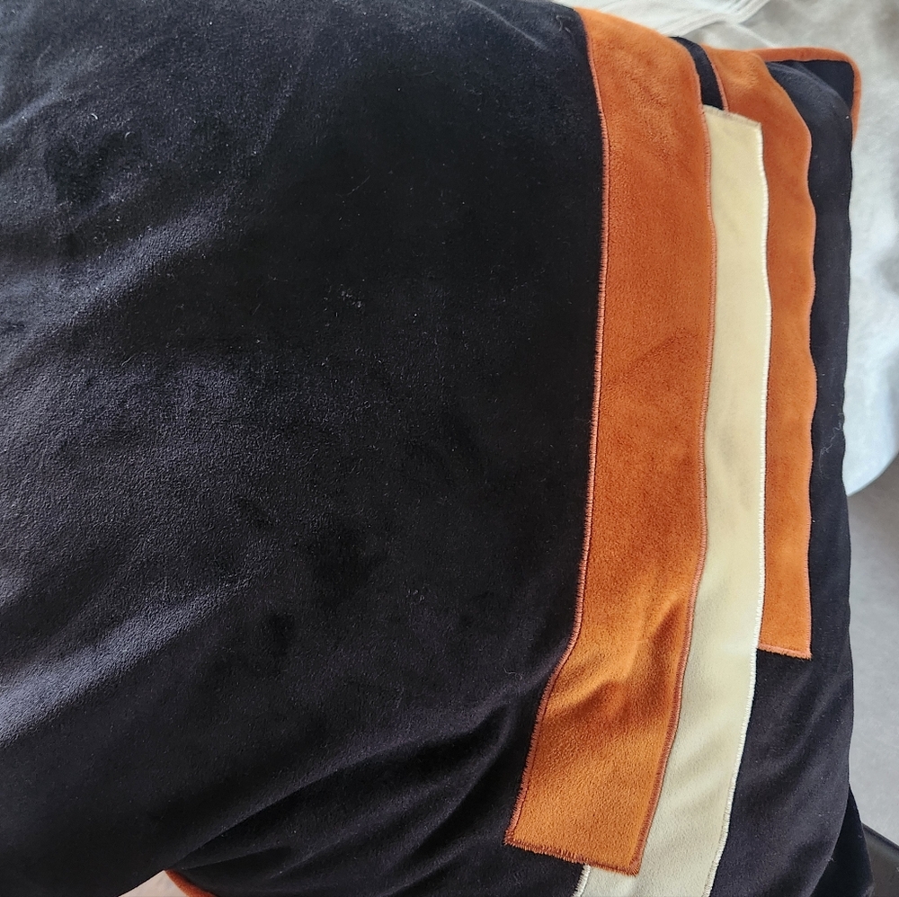 Decorative black and orange pillow cover.